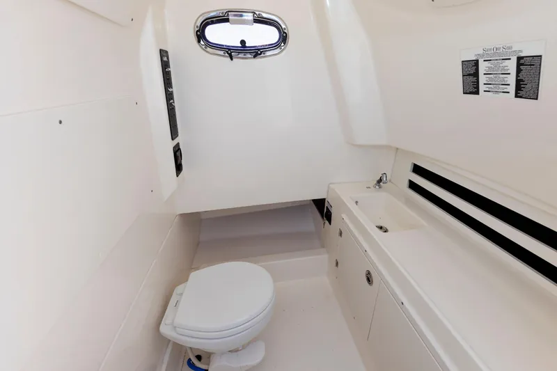 Slide: The Image of 2016 Boston Whaler 330 Outrage boat interior with toilet and sink. - 26