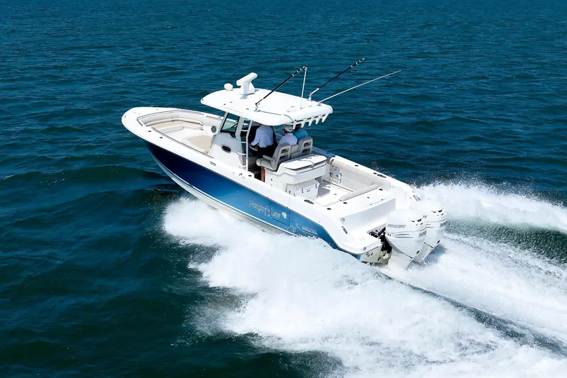 Slide: The Image of 2016 Boston Whaler 330 Outrage cruising on open water, showcasing sleek design and powerful engines. - 34