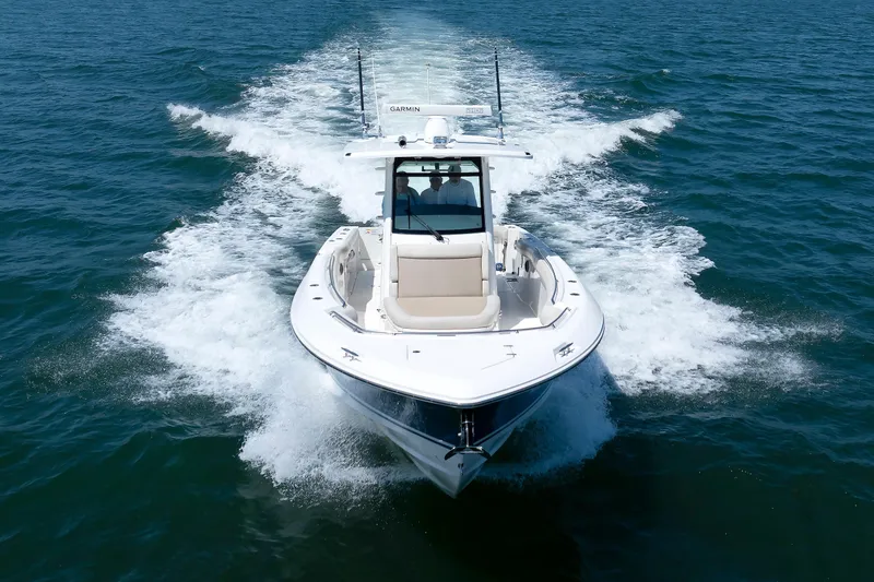 Slide: The Image of 2016 Boston Whaler 330 Outrage cruising on open water, creating a dynamic wake. - 35