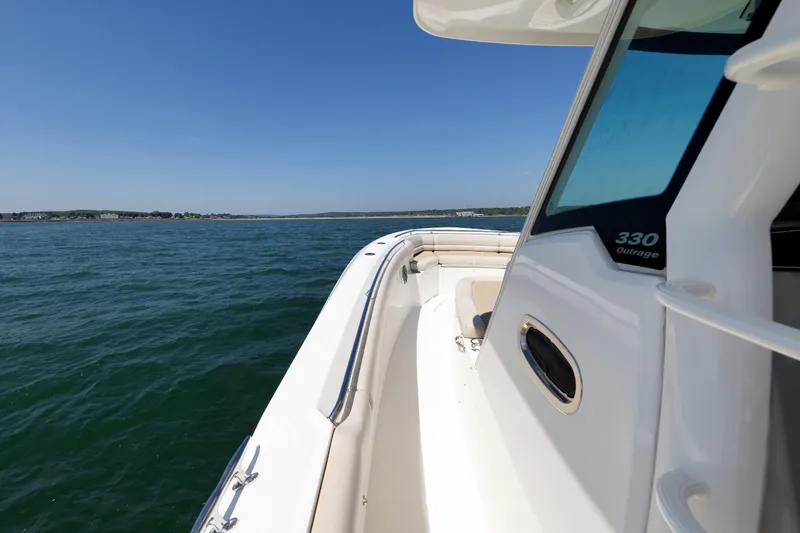 Slide: The Image of 2016 Boston Whaler 330 Outrage boat cruising on open water under clear blue sky. - 9
