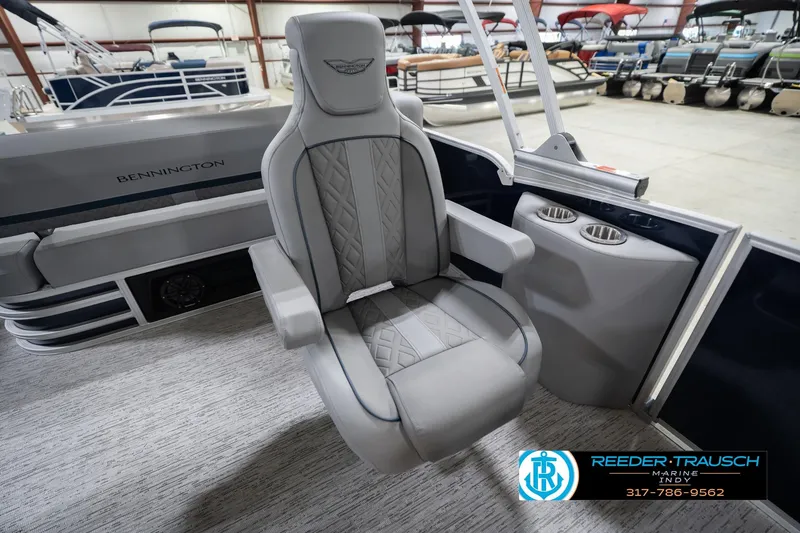 Slide: The Image of 2026 Bennington 22 MSB boat interior with luxury seating and cup holders in showroom. - 25