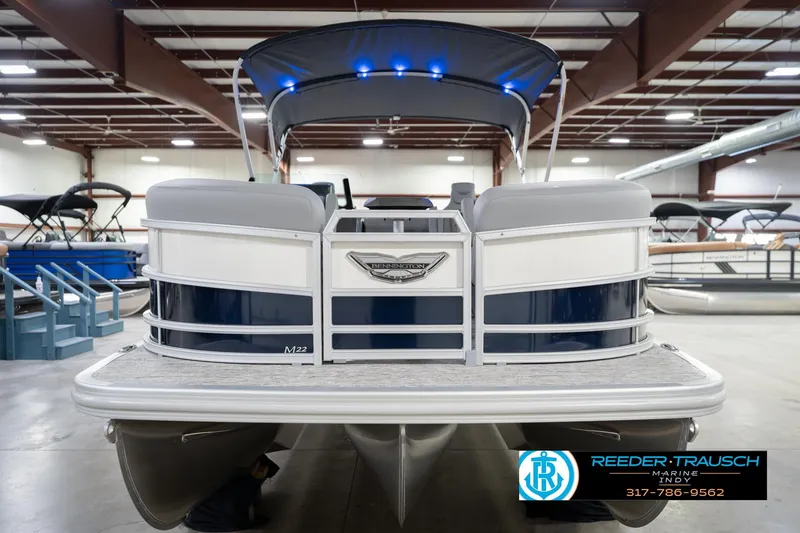Slide: The Image of 2026 Bennington 22 MSB pontoon boat in showroom, featuring sleek design and modern amenities. - 3