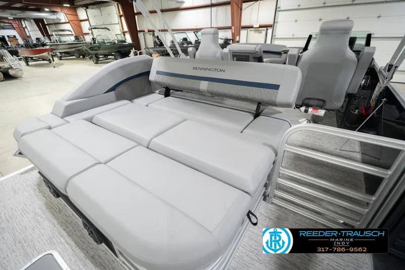 Slide: The Image of 2026 Bennington 22 MSB pontoon boat interior with plush seating in a showroom. - 31