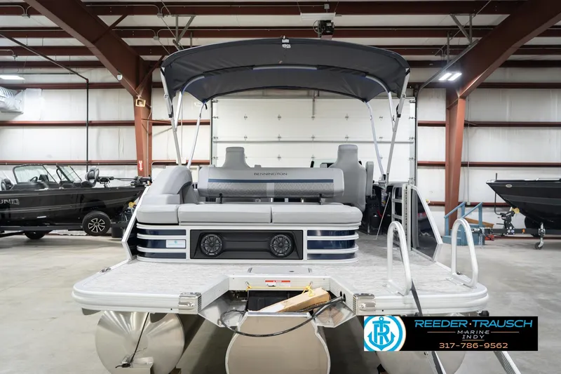 Slide: The Image of 2026 Bennington 22 MSB pontoon boat in a showroom with canopy and seating. - 7