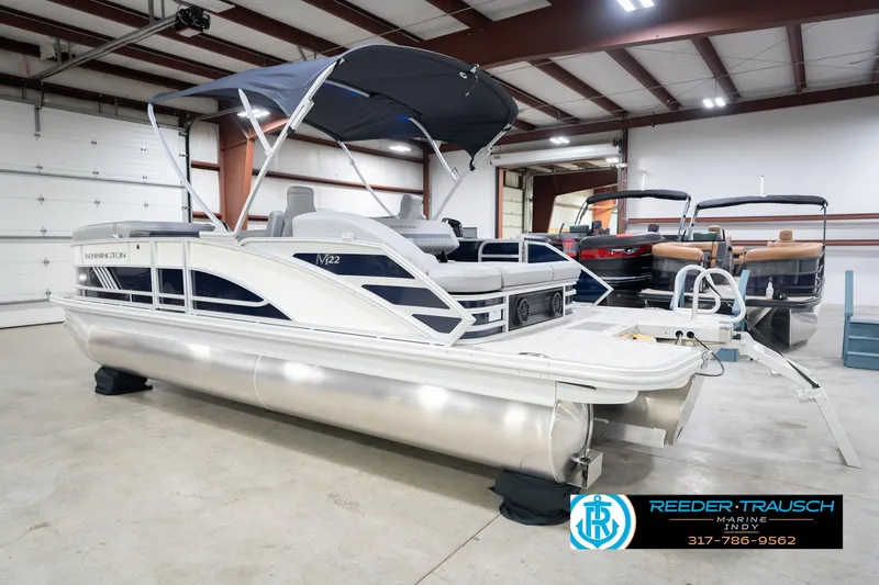 Slide: The Image of 2026 Bennington 22 MSB pontoon boat in showroom with canopy and seating. - 8