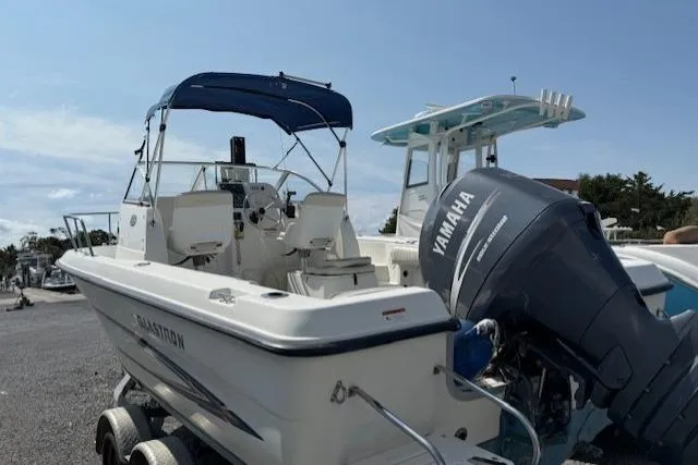 Slide: The Image of 2004 Glastron 213 WA boat with Yamaha outboard motor, parked on a trailer. - 3