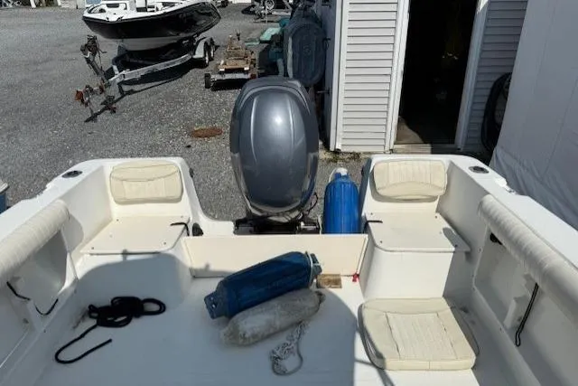 Slide: The Image of 2004 Glastron 213 WA boat interior with motor, docked outdoors. - 6