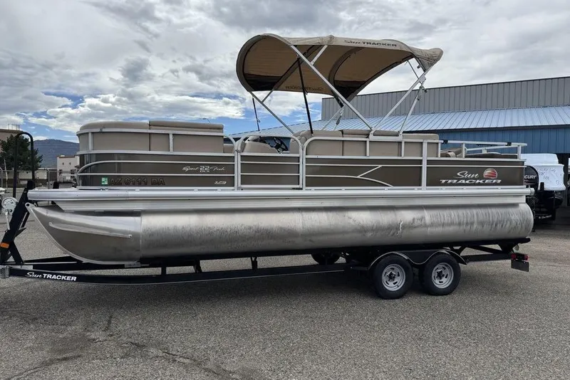 The Image of 2018 Sun Tracker SportFish 22 XP3 pontoon boat on trailer, parked outdoors. - 1