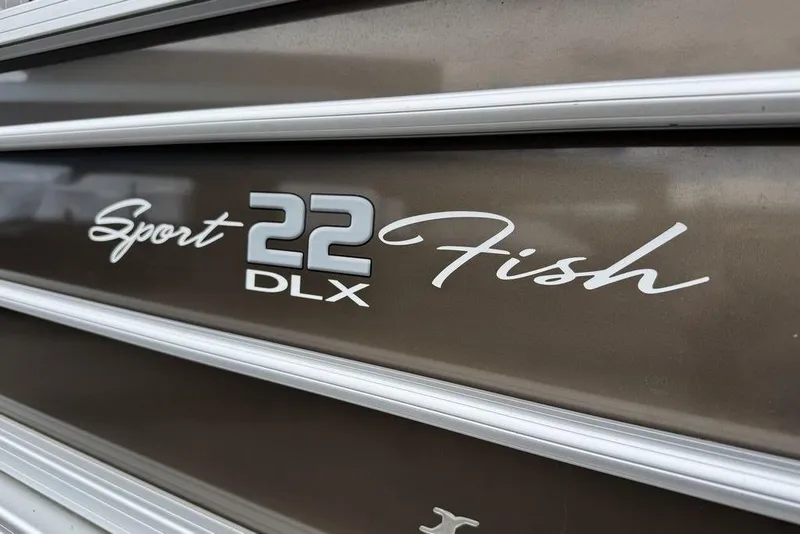 Slide: The Image of 2018 Sun Tracker SportFish 22 XP3 boat logo on metallic surface. - 14