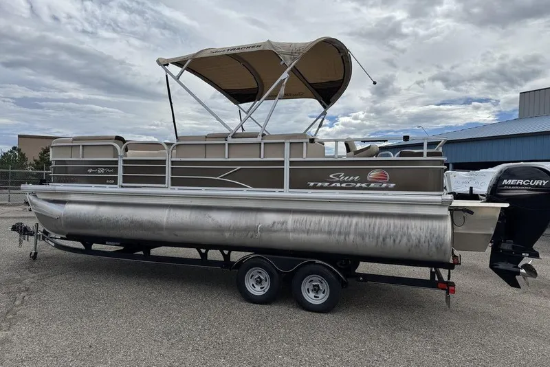 Slide: The Image of 2018 Sun Tracker SportFish 22 XP3 pontoon boat on trailer, under cloudy sky. - 20