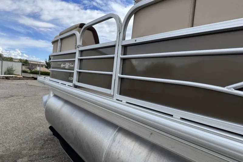Slide: The Image of 2018 Sun Tracker SportFish 22 XP3 pontoon boat, side view with railing and clear sky. - 25