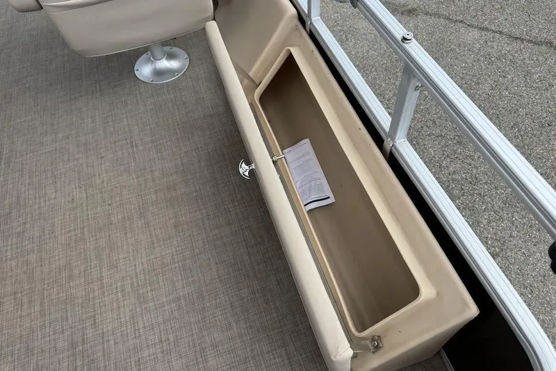 Slide: The Image of 2018 Sun Tracker SportFish 22 XP3 storage compartment with document inside, beige interior. - 37