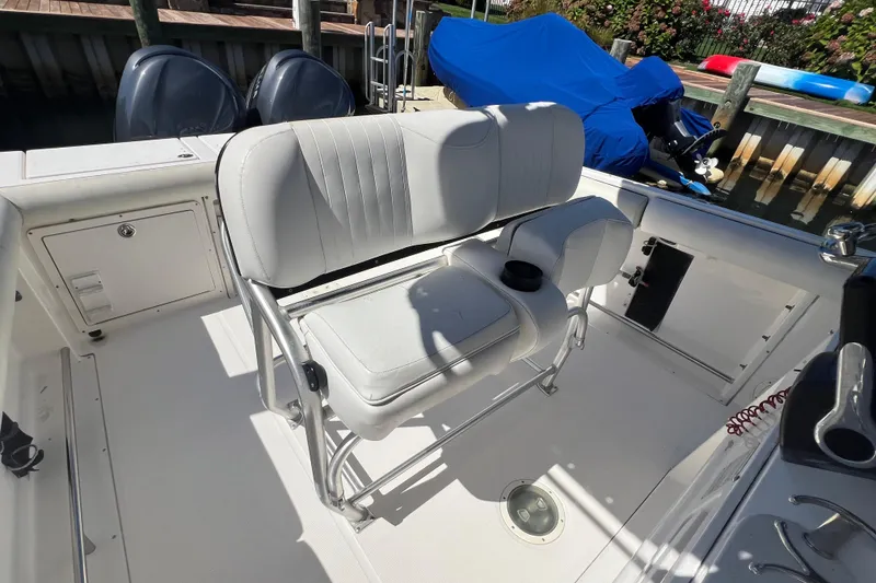 Slide: The Image of 2004 Robalo R260 Center Console boat interior with white seating and dual engines. - 15