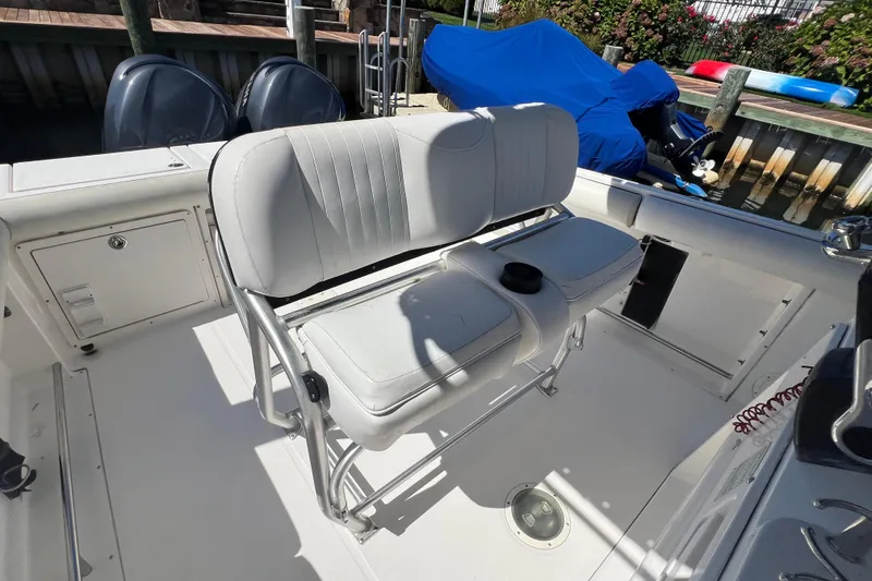 Slide: The Image of 2004 Robalo R260 Center Console boat interior with cushioned seating and dual engines. - 16