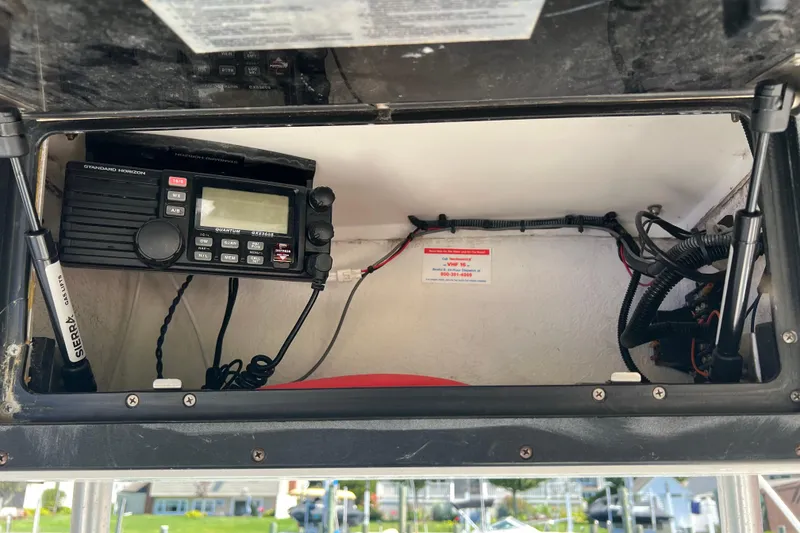 Slide: The Image of 2004 Robalo R260 Center Console boat electronics compartment with radio and wiring. - 28