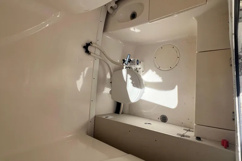Slide: The Image of 2004 Robalo R260 Center Console boat interior with compact marine toilet. - 6