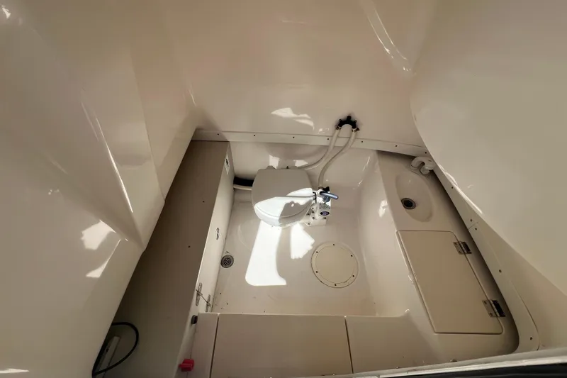 Slide: The Image of 2004 Robalo R260 Center Console boat interior with compact marine toilet. - 7