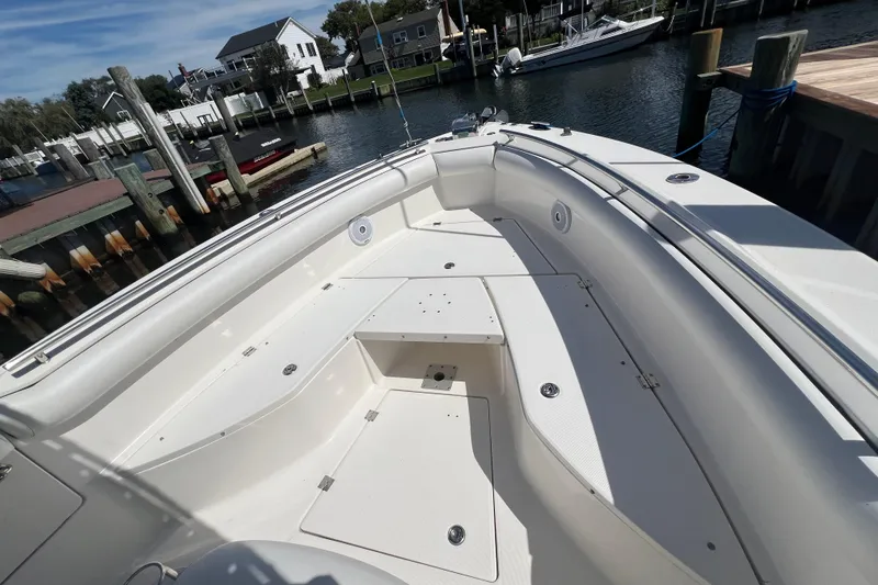 Slide: The Image of 2004 Robalo R260 Center Console boat docked in a marina under clear skies. - 8