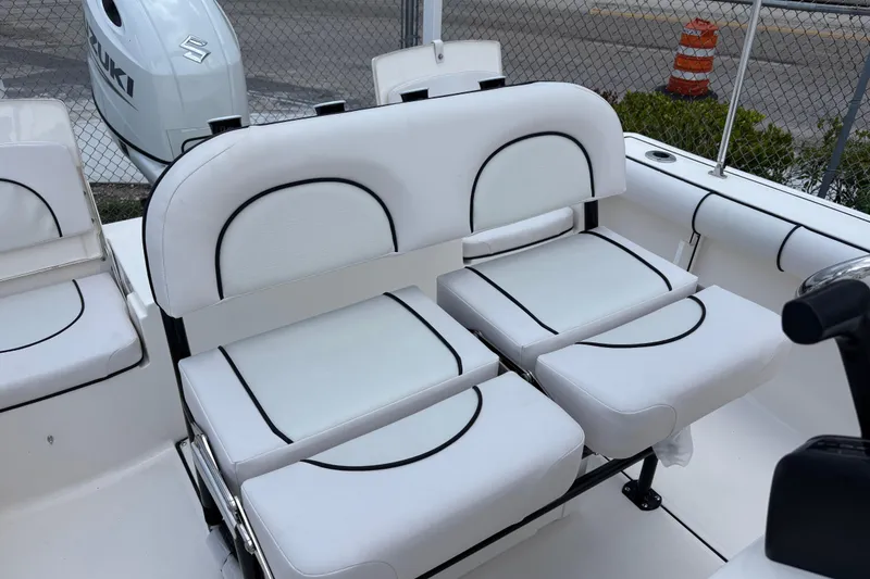 Slide: The Image of 2026 Sea Born LX21 Center Console boat seating with Suzuki engine in background. - 11