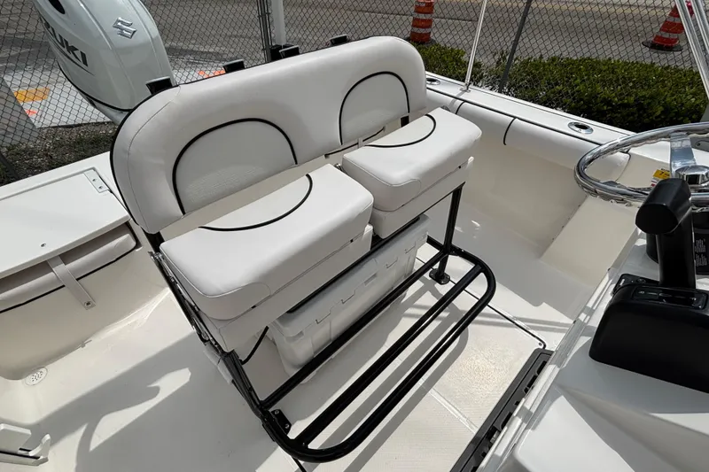 Slide: The Image of 2026 Sea Born LX21 Center Console boat interior with white seating and steering wheel. - 13