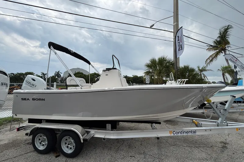 Slide: The Image of 2026 Sea Born LX21 Center Console boat on trailer, parked outdoors under cloudy sky. - 2