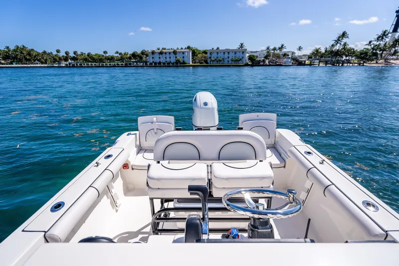 Slide: The Image of 2026 Sea Born LX21 Center Console boat on clear blue water, with scenic shoreline view. - 22