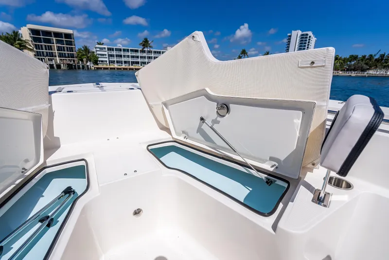 Slide: The Image of 2026 Sea Born LX21 Center Console boat with open storage compartments, dockside view. - 26