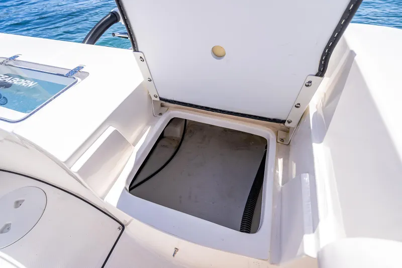 Slide: The Image of 2026 Sea Born LX21 Center Console boat storage compartment open on deck. - 46