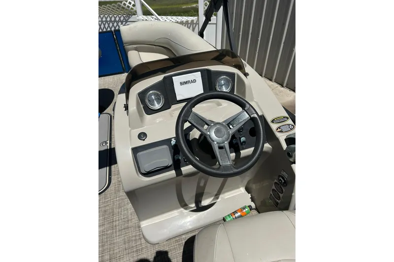 Slide: The Image of 2020 Cypress Cay Seabreeze 232 boat dashboard with steering wheel and controls. - 11