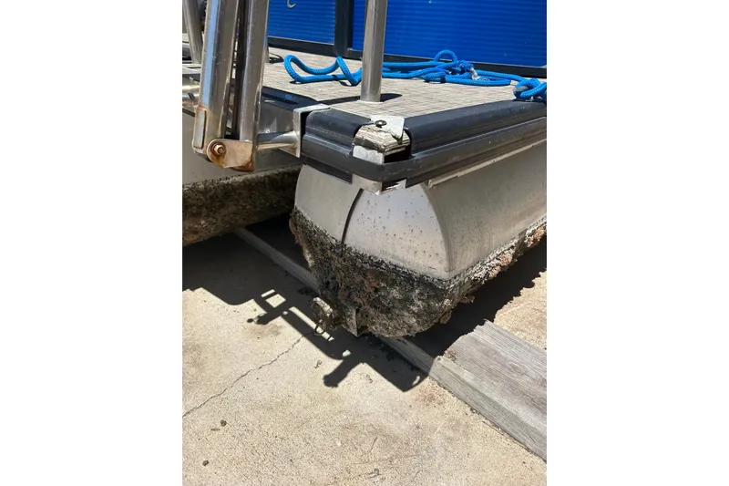 Slide: The Image of 2020 Cypress Cay Seabreeze 232 pontoon boat with visible hull wear and marine growth. - 4