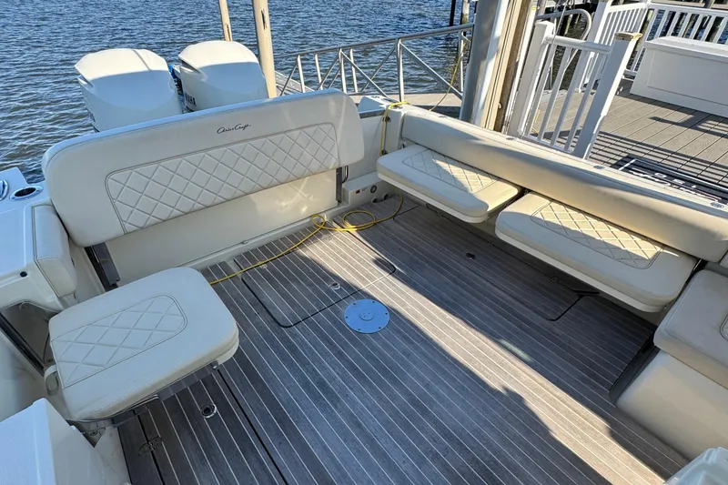 Slide: The Image of 2018 Chris-Craft Calypso 30 boat interior with cushioned seating and wooden deck. - 10