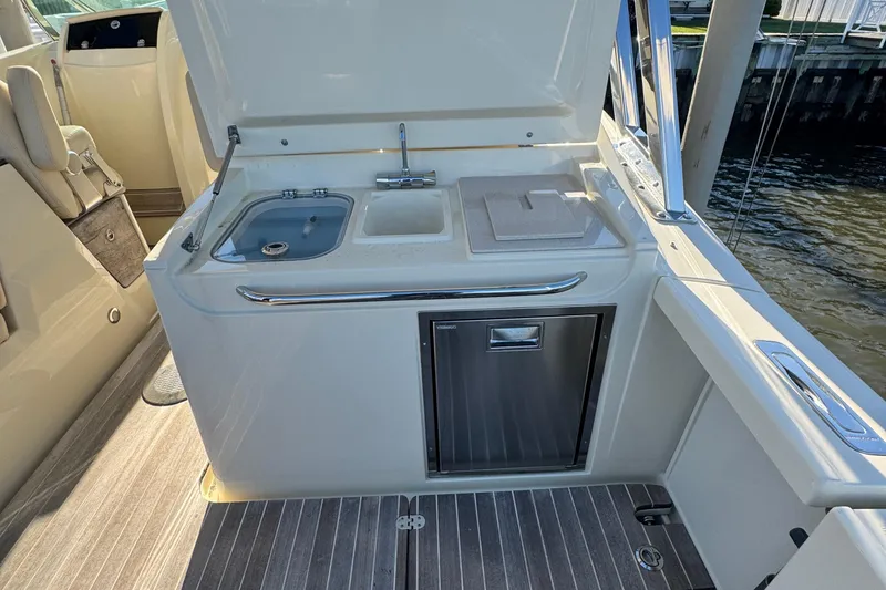 Slide: The Image of 2018 Chris-Craft Calypso 30 boat kitchenette with sink, stove, and storage. - 13