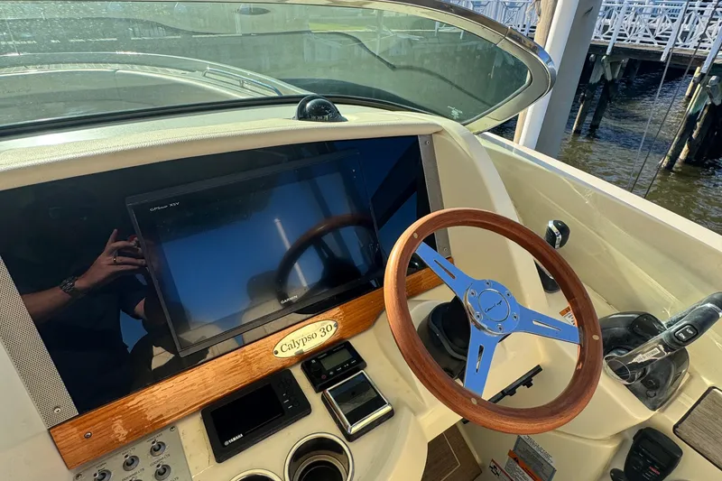Slide: The Image of 2018 Chris-Craft Calypso 30 helm with wooden steering wheel and navigation display. - 5