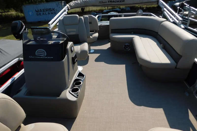 Slide: The Image of 2025 Sun Tracker Bass Buggy pontoon boat interior with beige seating and steering console. - 14