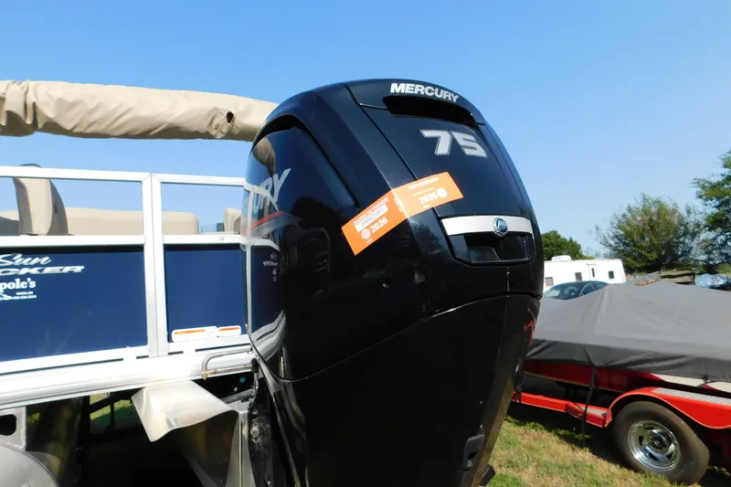 Slide: The Image of 2025 Sun Tracker Bass Buggy with Mercury 75 outboard motor, parked outdoors. - 2