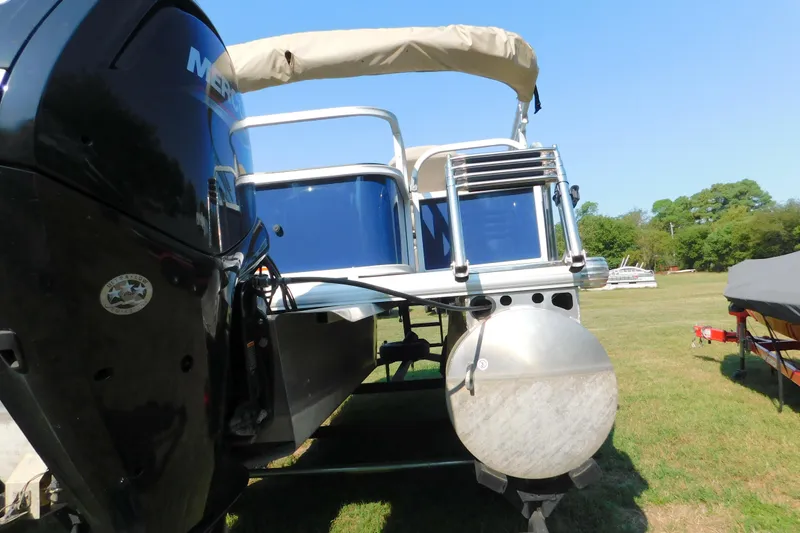 Slide: The Image of 2025 Sun Tracker Bass Buggy pontoon boat with Mercury engine on grassy field. - 3