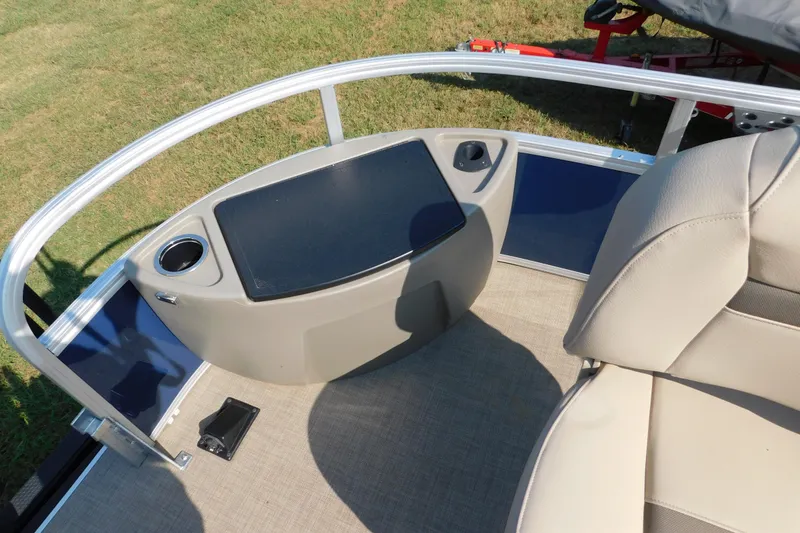 Slide: The Image of 2025 Sun Tracker Bass Buggy boat console with cup holder and beige seating. - 6