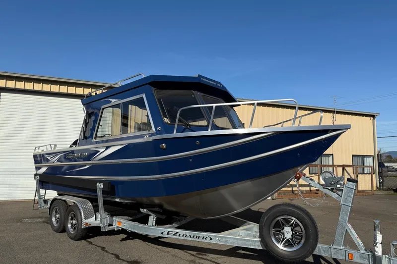 The Image of 2025 Thunder Jet 24 Alexis Pro boat on trailer, parked outside industrial building. - 0