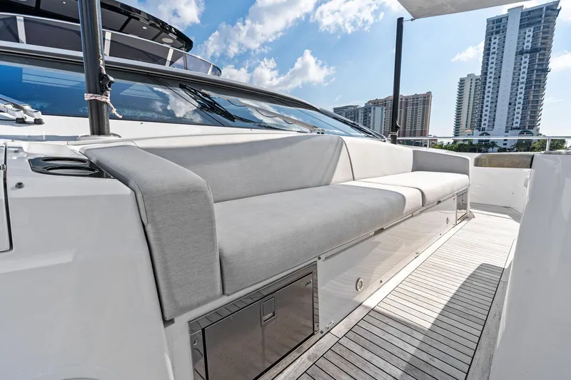 Slide: The Image of 2024 Sunseeker 90 Ocean yacht deck with modern seating and cityscape view. - 13
