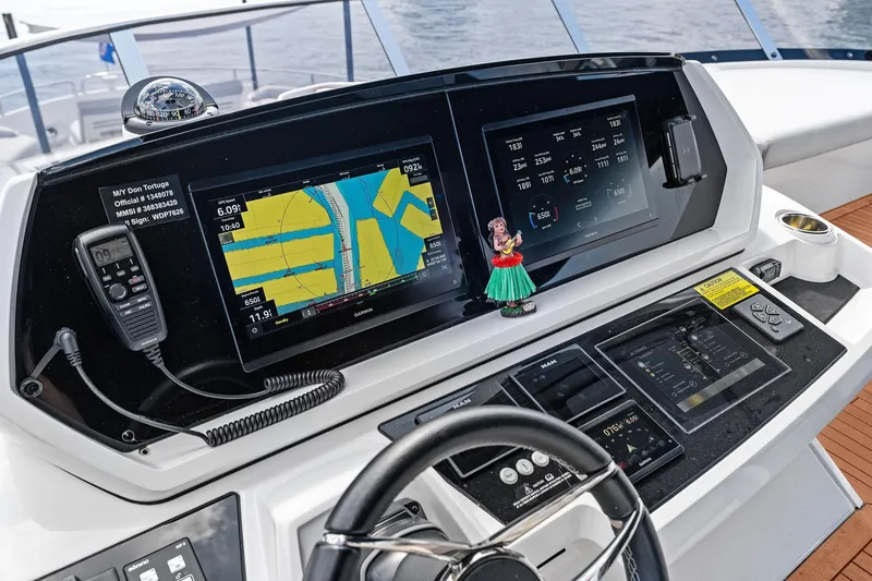 Slide: The Image of 2024 Sunseeker 90 Ocean yacht helm with navigation screens and controls. - 15