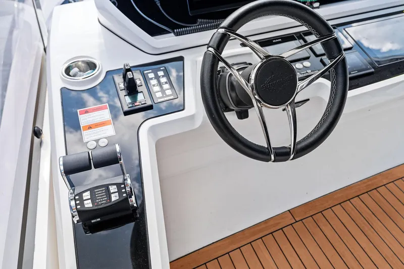 Slide: The Image of Steering wheel and controls of 2024 Sunseeker 90 Ocean yacht, featuring sleek design and modern technology. - 16