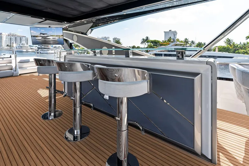 Slide: The Image of Luxurious Sunseeker 90 Ocean 2024 yacht deck with bar stools and scenic marina view. - 18