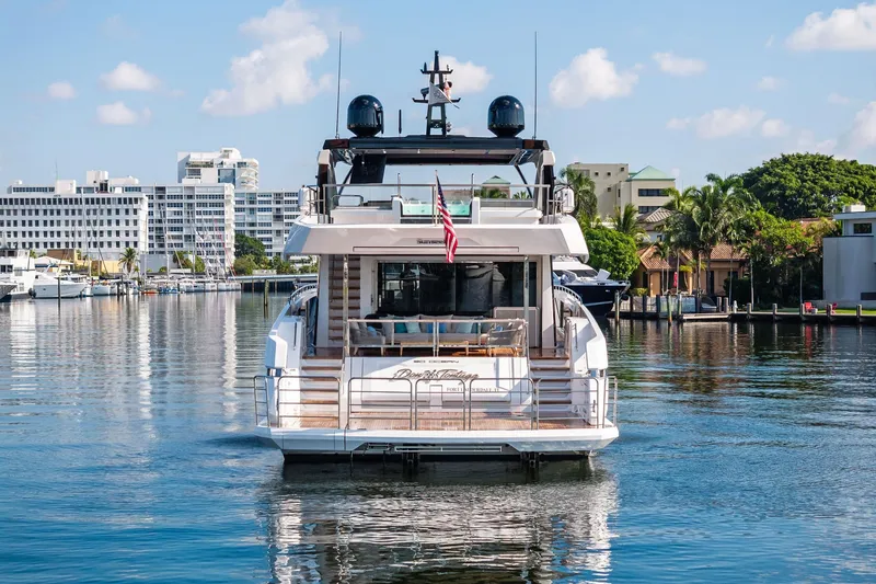 Slide: The Image of 2024 Sunseeker 90 Ocean yacht docked in a scenic marina setting. - 2