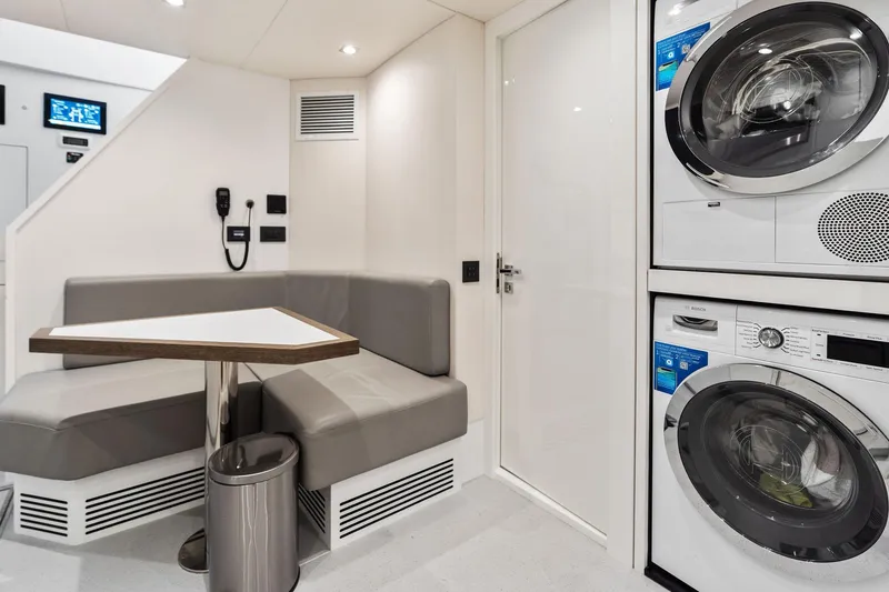 Slide: The Image of Modern Sunseeker 90 Ocean 2024 yacht interior with seating area and stacked laundry appliances. - 69