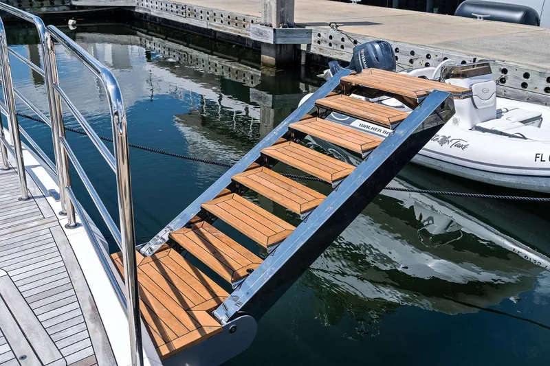 Slide: The Image of Luxury yacht Sunseeker 90 Ocean 2024 with elegant wooden boarding stairs at marina. - 9