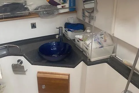 Slide: The Image of 2020 Cutwater C-32 C bathroom with blue sink and storage shelves. - 21