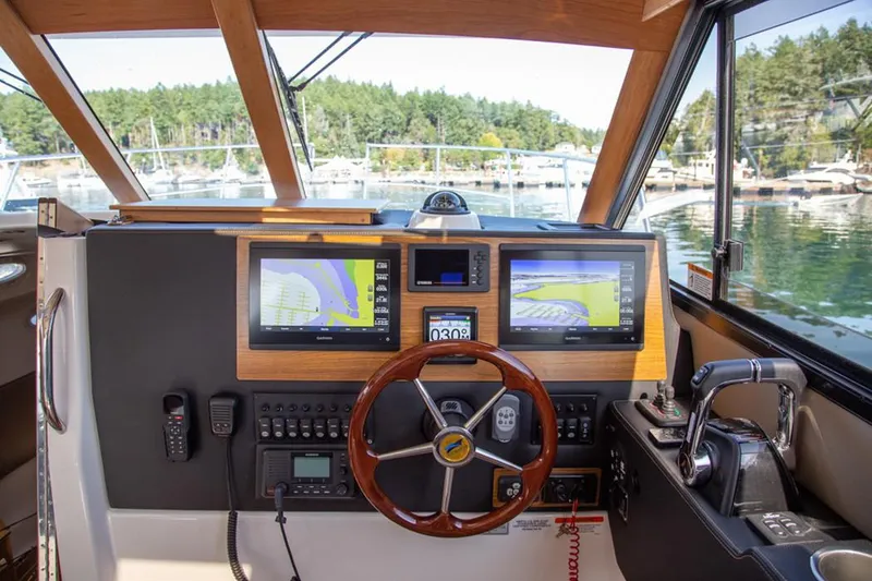 Slide: The Image of Manufacturer Provided Image: 2020 Cutwater C-32 C boat helm with dual navigation screens and wooden steering wheel. - 8
