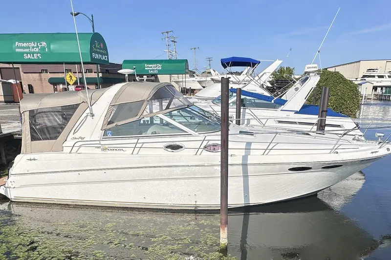 The Image of 2000 Sea Ray 290 Sundancer docked at marina, with green awnings in background. - 0