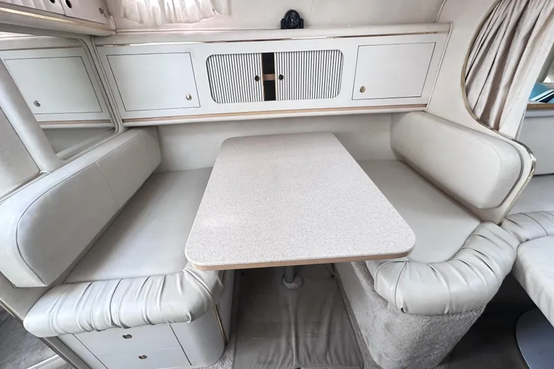 Slide: The Image of Interior of 2000 Sea Ray 290 Sundancer with dining area and cushioned seating. - 12
