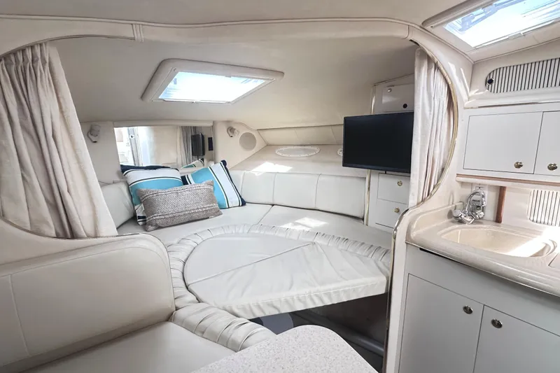 Slide: The Image of Interior of 2000 Sea Ray 290 Sundancer with cozy seating, TV, and kitchenette. - 15